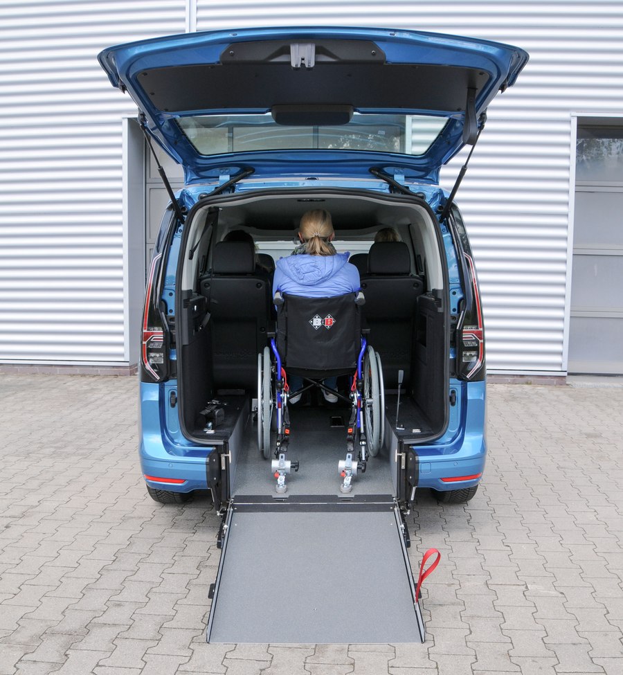 VW Caddy mit Heckausschnitt und Rampe – Rollstuhl fährt von hinten ins Fahrzeug